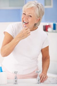 senior woman brushing teeth